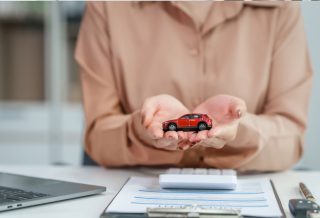 une voiture miniature dans les mains d'une personne