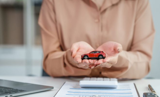 une voiture miniature dans les mains d'une personne